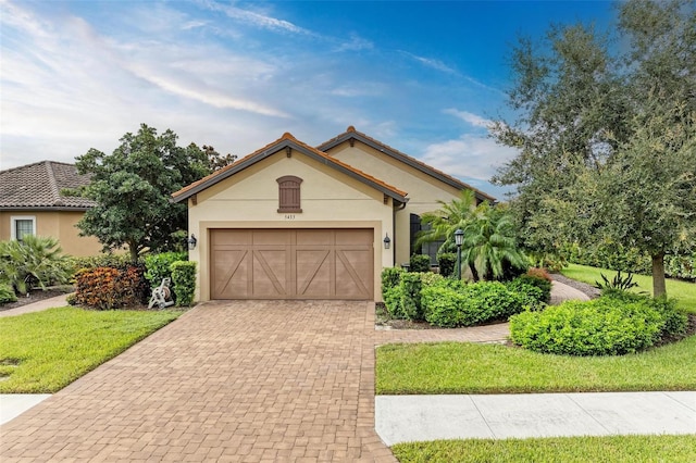 mediterranean / spanish-style house with a garage and a front yard