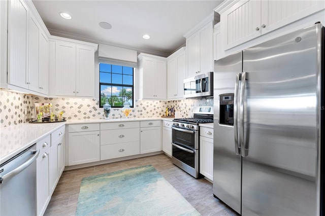 kitchen featuring light hardwood / wood-style floors, stainless steel appliances, white cabinets, and tasteful backsplash