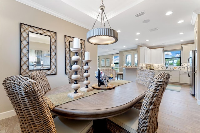 dining room featuring light hardwood / wood-style floors and crown molding