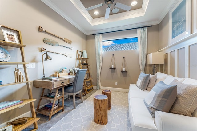 office space with a tray ceiling, ceiling fan, and ornamental molding