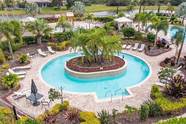 view of pool with a water view and a patio