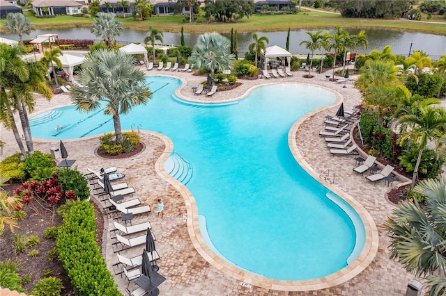 view of swimming pool with a water view and a patio