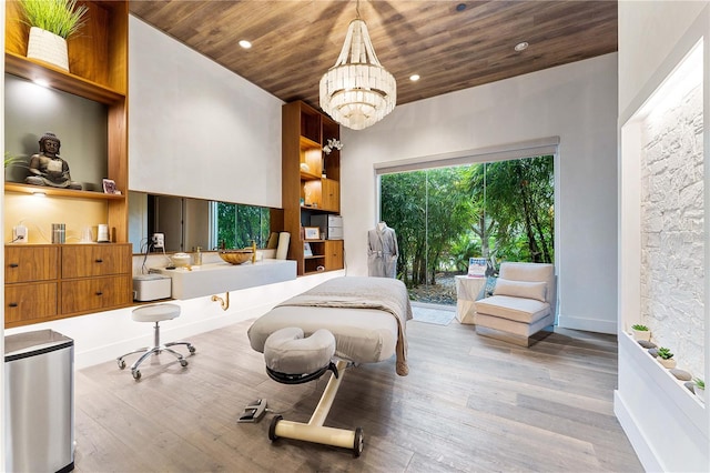 bedroom with an inviting chandelier, hardwood / wood-style floors, and wooden ceiling