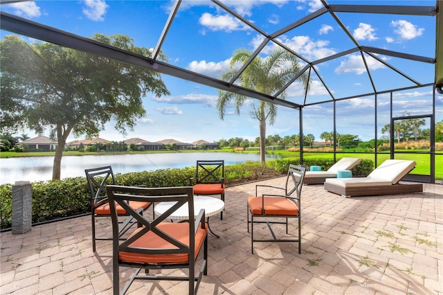 view of patio featuring glass enclosure and a water view