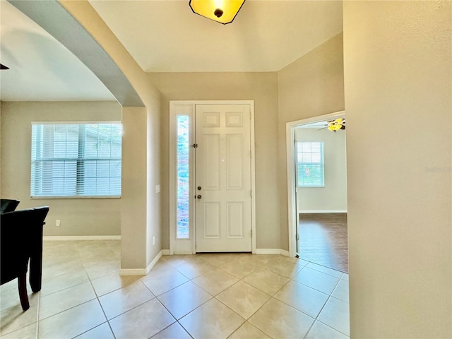 entryway with ceiling fan, light tile patterned floors, and a wealth of natural light