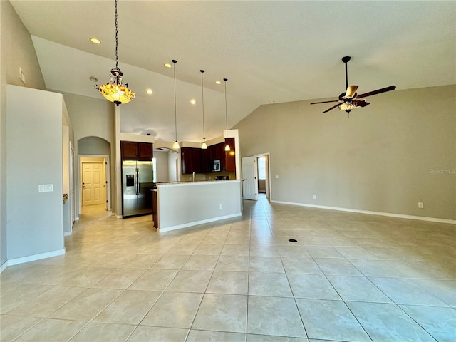 kitchen with a kitchen island, appliances with stainless steel finishes, pendant lighting, and high vaulted ceiling