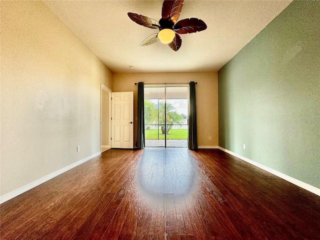 unfurnished room with ceiling fan, a textured ceiling, and dark hardwood / wood-style flooring