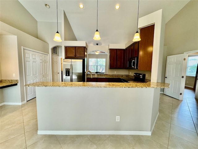 kitchen with high vaulted ceiling, stainless steel appliances, light stone countertops, and decorative light fixtures