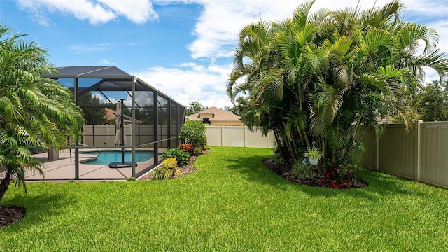 view of yard with glass enclosure and a fenced in pool