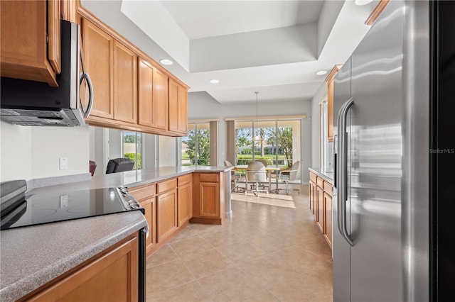 kitchen with decorative light fixtures, light tile patterned floors, stainless steel appliances, and kitchen peninsula