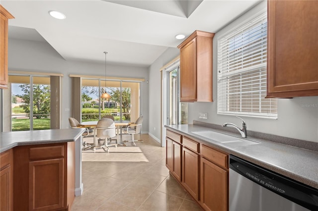 kitchen with plenty of natural light, stainless steel dishwasher, sink, and decorative light fixtures