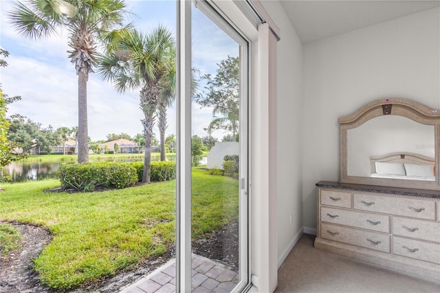 doorway to outside featuring light carpet and a water view