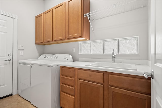 laundry area featuring cabinets, washer and clothes dryer, sink, and light tile patterned floors