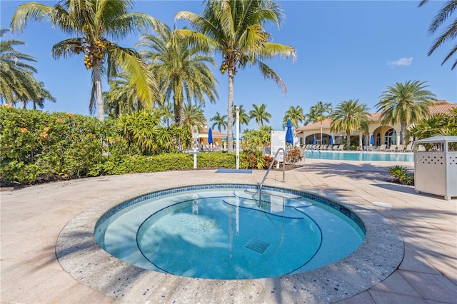 view of swimming pool with a community hot tub and a patio area