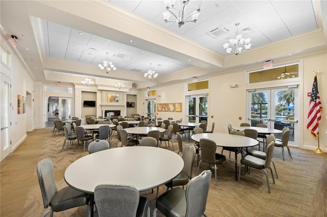 dining space with ornamental molding, light hardwood / wood-style floors, a notable chandelier, and french doors