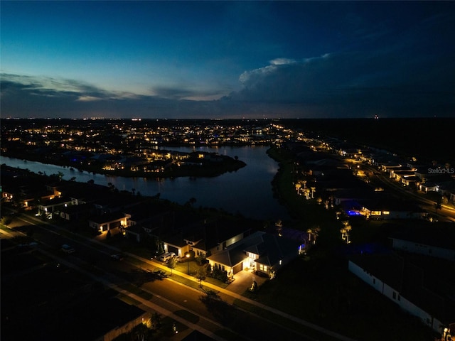 aerial view at dusk featuring a water view