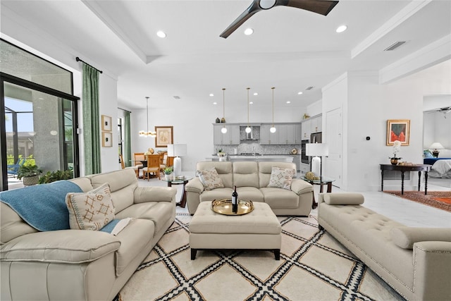 living room featuring a raised ceiling, ornamental molding, and ceiling fan