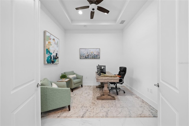 office area featuring ceiling fan and a raised ceiling