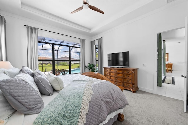 bedroom with ceiling fan, a raised ceiling, and carpet flooring