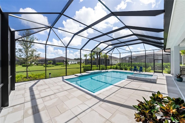 view of pool with an in ground hot tub, glass enclosure, a patio, and a lawn