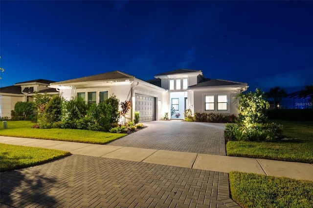 view of front facade with a yard and a garage