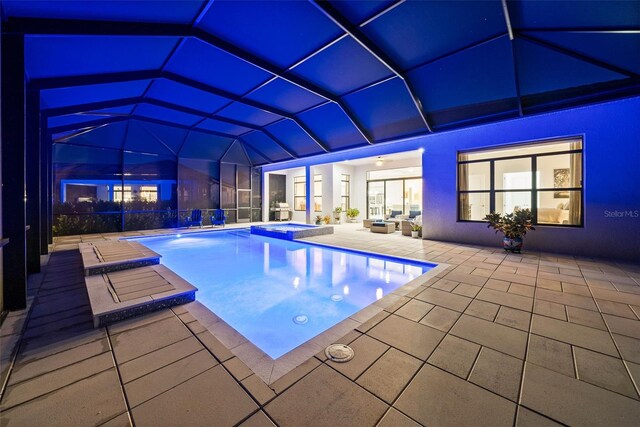 view of swimming pool with a lanai, a patio, and an in ground hot tub