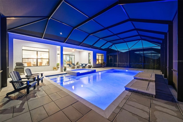 view of pool with glass enclosure and a patio area