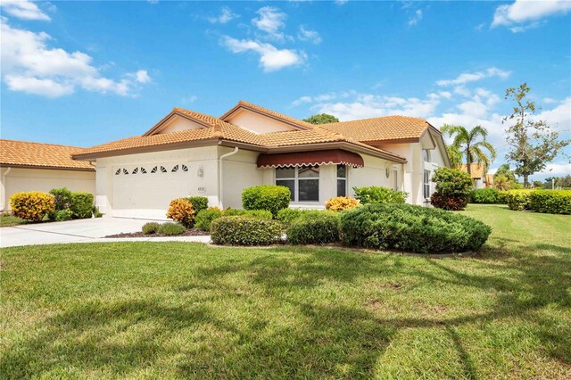 4995 Pepperwood Pl, Venice, FL 34293 - mediterranean / spanish-style home featuring stucco siding, a tiled roof, driveway, a front yard, and a garage