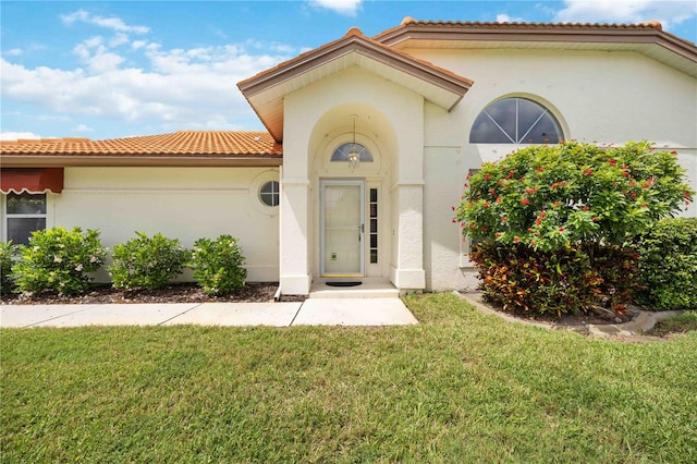 view of exterior entry featuring a yard