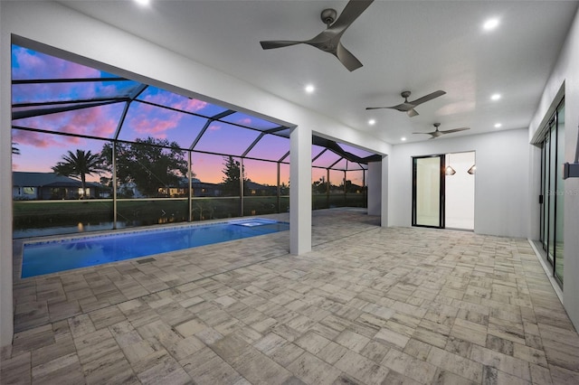 pool at dusk featuring ceiling fan