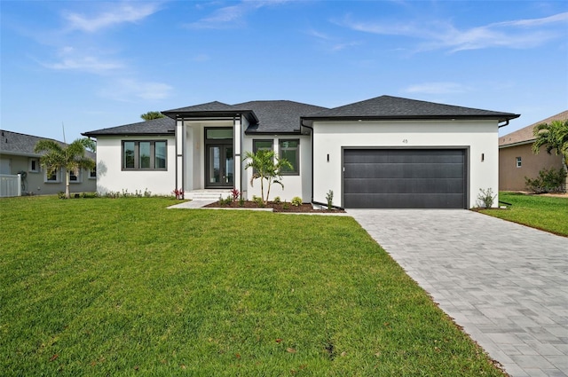 prairie-style home featuring a garage and a front lawn