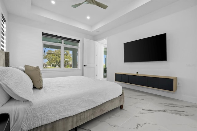 bedroom with a tray ceiling and ceiling fan