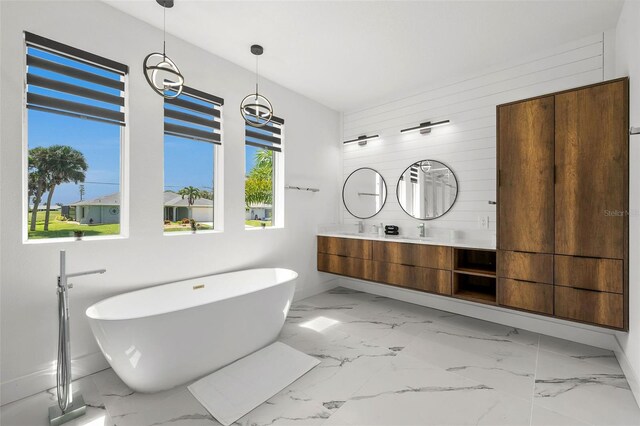 bathroom featuring vanity, plenty of natural light, a tub, and wooden walls