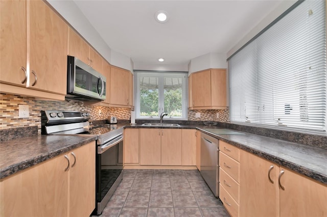 kitchen featuring sink, light tile patterned floors, backsplash, stainless steel appliances, and light brown cabinets