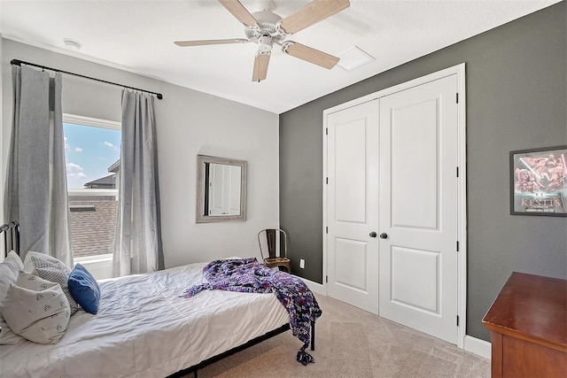 carpeted bedroom featuring ceiling fan, baseboards, and a closet