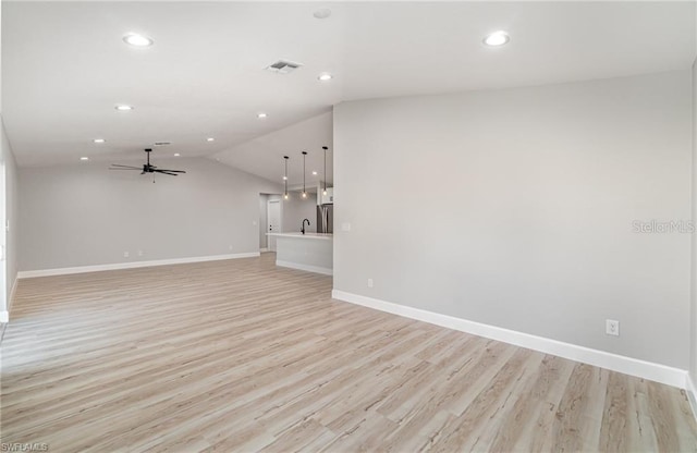 unfurnished living room featuring vaulted ceiling, light wood-type flooring, and ceiling fan