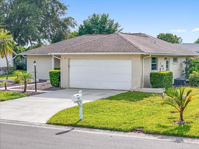 single story home featuring central air condition unit, a garage, and a front yard