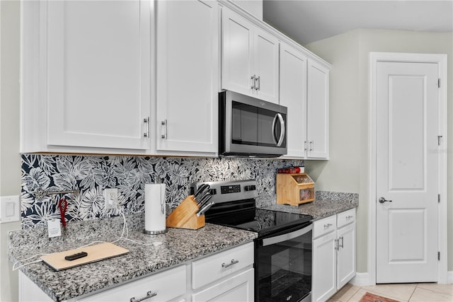 kitchen featuring white cabinets, backsplash, appliances with stainless steel finishes, light tile patterned floors, and light stone countertops