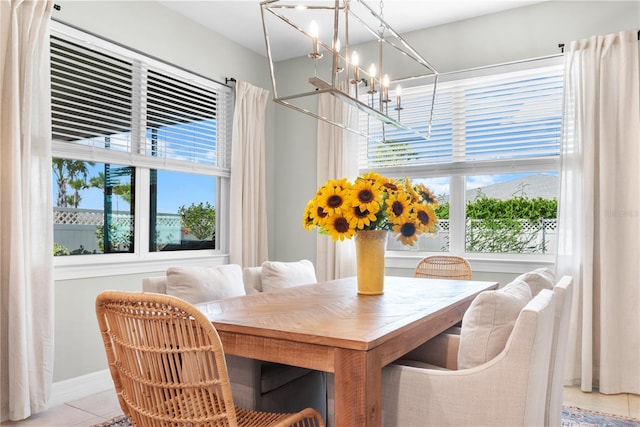 dining area with light tile patterned flooring, breakfast area, and a chandelier