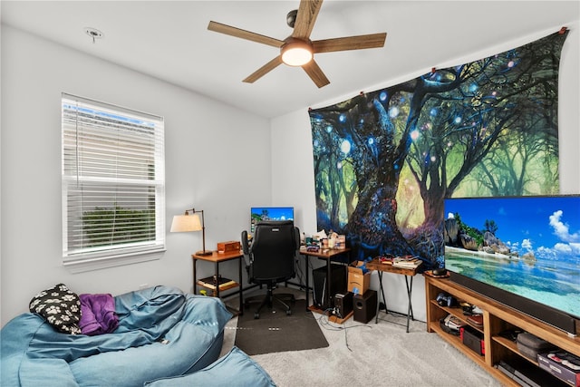 carpeted home office with a wealth of natural light and ceiling fan