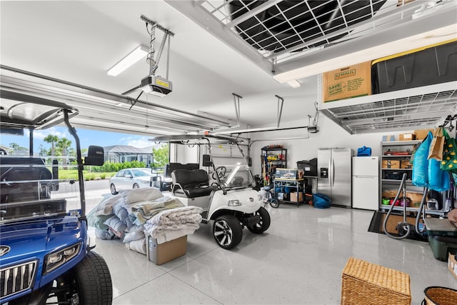 garage featuring a garage door opener, stainless steel fridge with ice dispenser, and white fridge