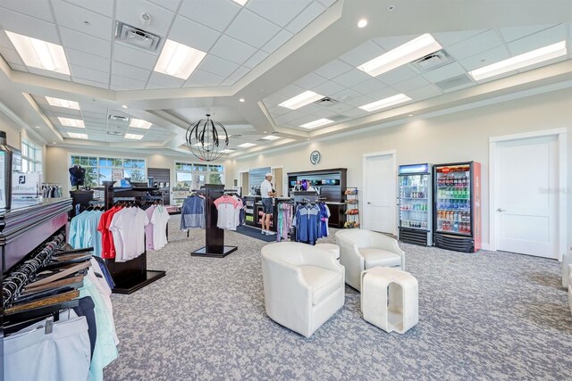 interior space featuring a drop ceiling, a chandelier, and carpet flooring