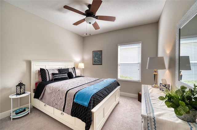 bedroom featuring a textured ceiling, ceiling fan, and light carpet