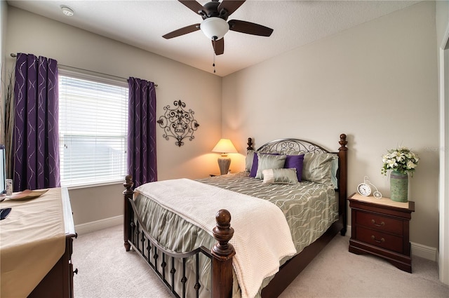 carpeted bedroom with a textured ceiling, ceiling fan, and multiple windows