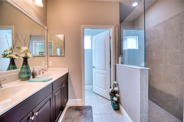 bathroom with vanity, tiled shower, and tile patterned flooring