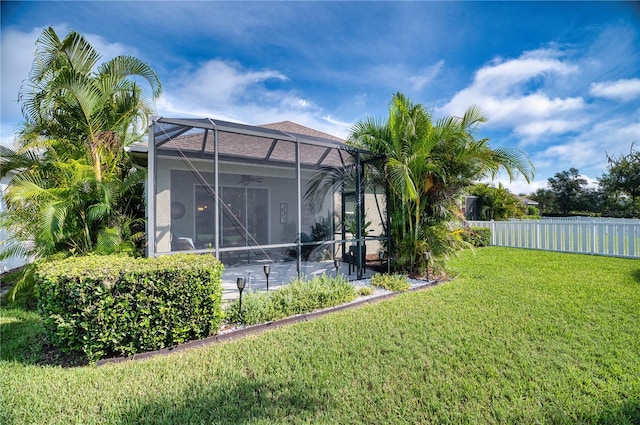 view of yard with glass enclosure and a swimming pool