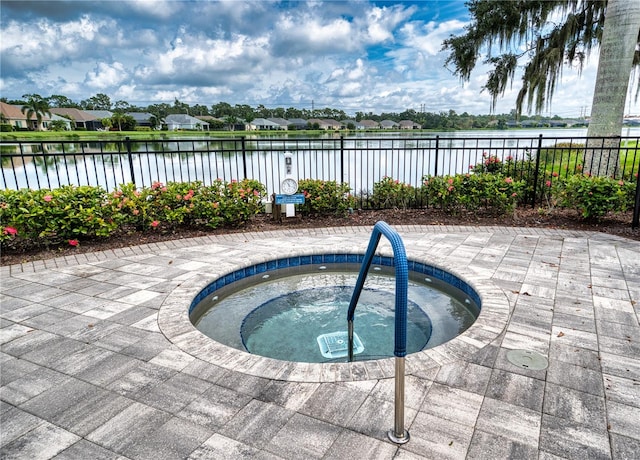 view of swimming pool featuring a community hot tub and a water view