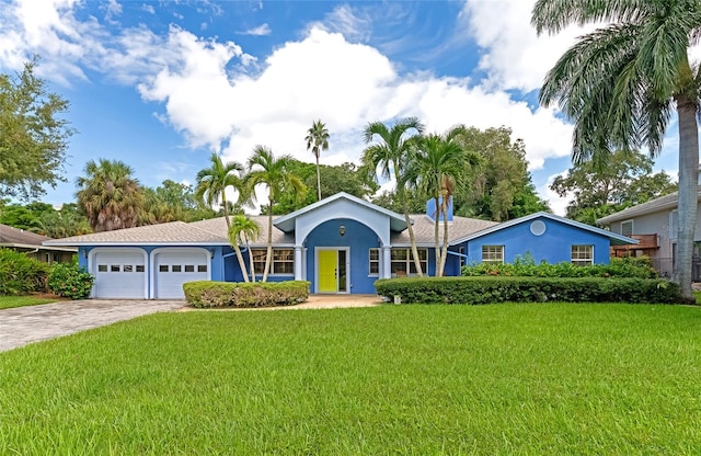 ranch-style home featuring a garage and a front lawn