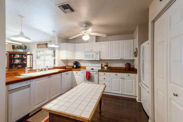 kitchen featuring white cabinetry, pendant lighting, butcher block counters, and white appliances