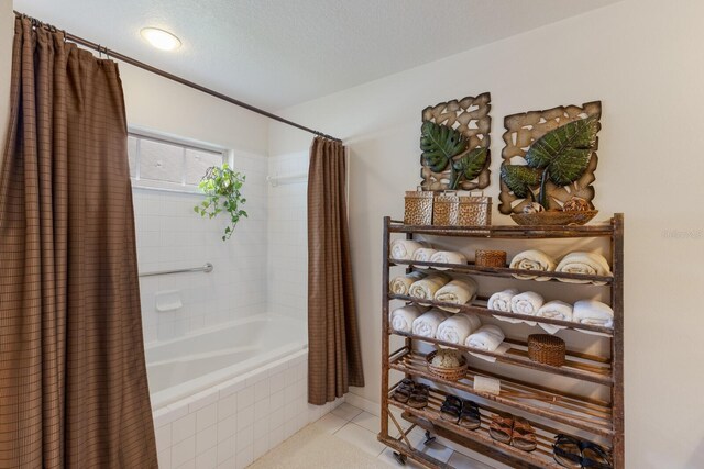 bathroom featuring tile patterned floors, a textured ceiling, and shower / bathtub combination with curtain